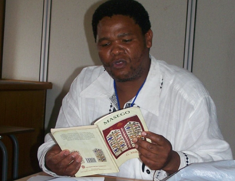 Dr Gomolemo Mokae reading his book